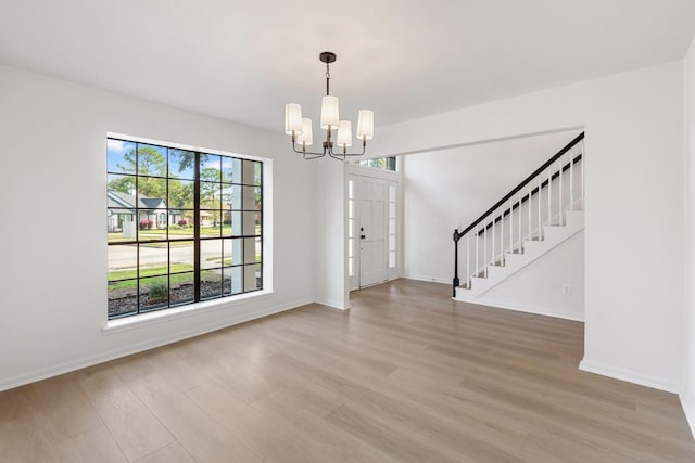 foyer entrance with an inviting chandelier and light wood-type flooring