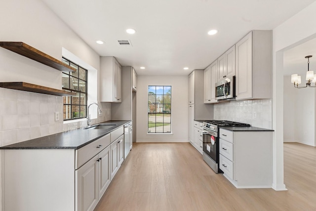 kitchen featuring stainless steel appliances, white cabinetry, sink, and light wood-type flooring