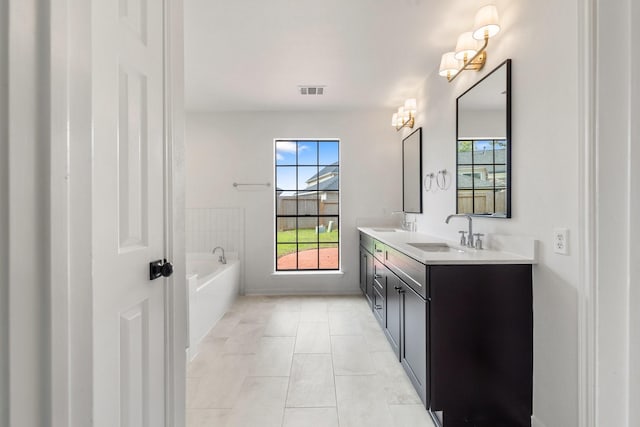 bathroom with tile patterned floors, vanity, and a washtub