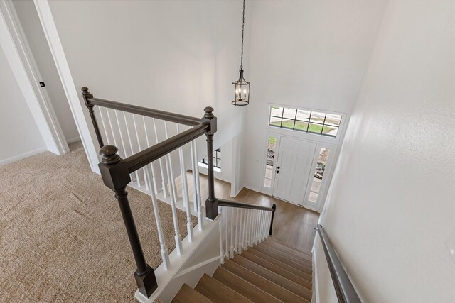 staircase featuring a towering ceiling and a notable chandelier