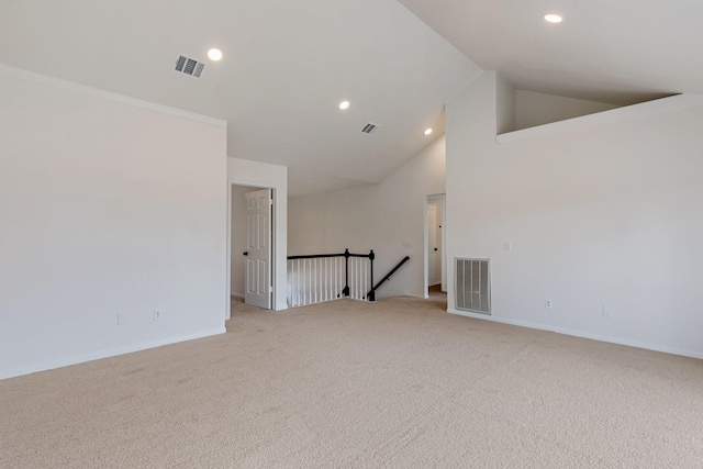 unfurnished room with light carpet and high vaulted ceiling