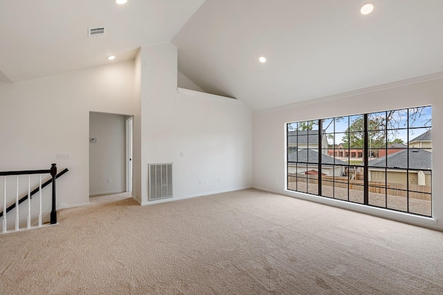 empty room featuring light colored carpet and high vaulted ceiling