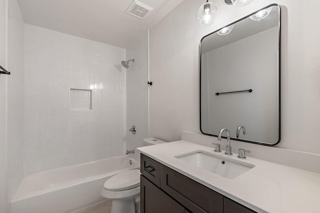 full bathroom with tiled shower / bath, vanity, and toilet