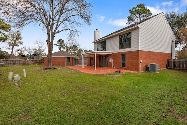 rear view of house featuring central AC, a yard, and a patio