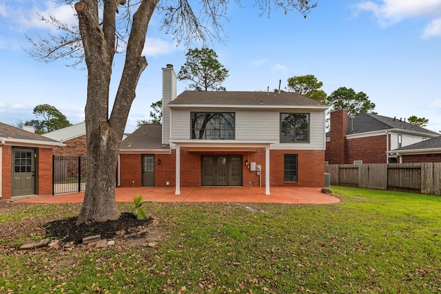 back of property featuring french doors, a yard, and a patio