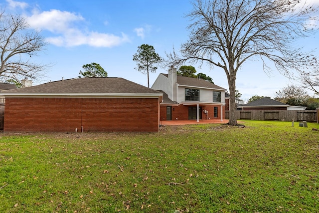 rear view of property with a yard and a patio area