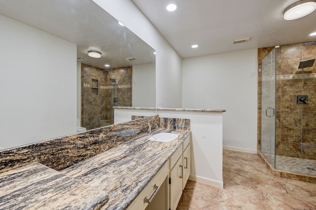 bathroom featuring an enclosed shower and vanity