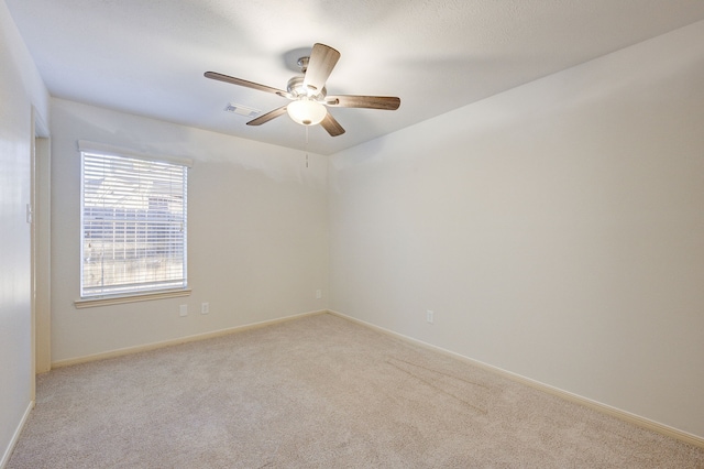 carpeted spare room with ceiling fan