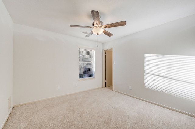 spare room featuring light colored carpet and ceiling fan