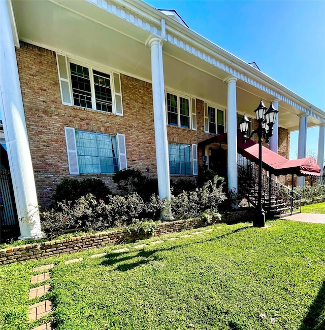 view of front of home with brick siding and a front lawn