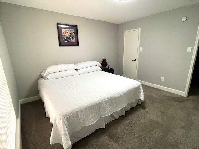 bedroom featuring baseboards and dark carpet