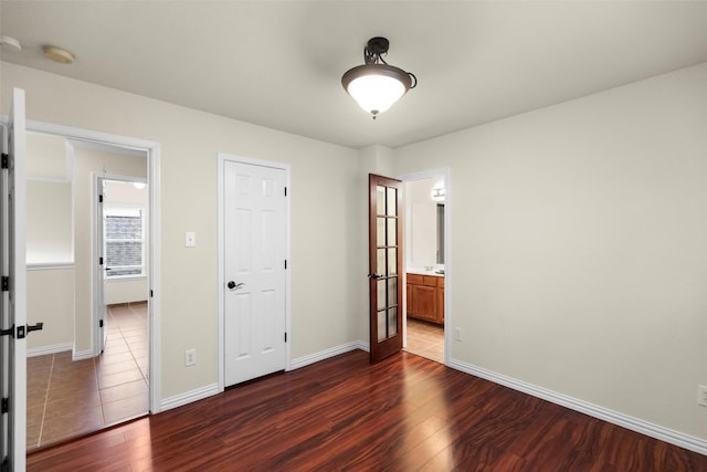 unfurnished bedroom featuring french doors and dark hardwood / wood-style floors