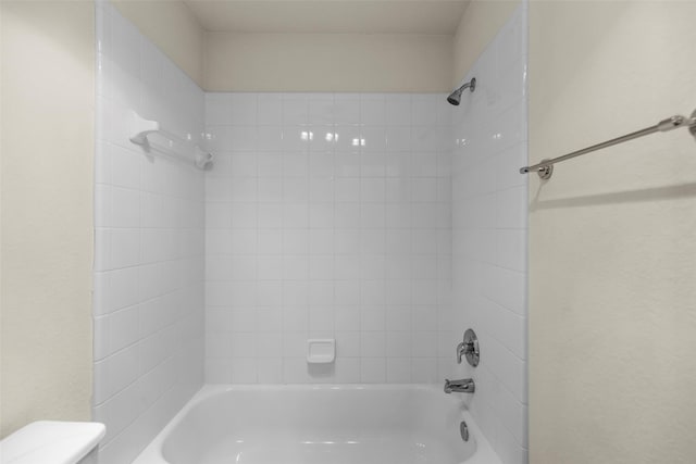 bathroom featuring shower / washtub combination and toilet