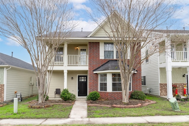 view of front of house featuring a front yard and a balcony