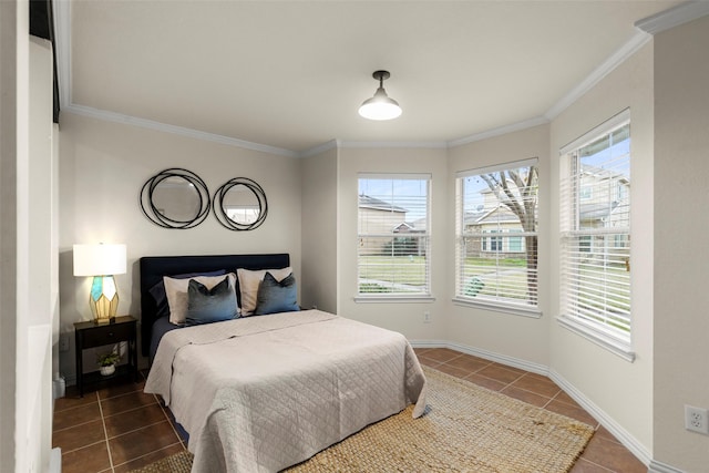 bedroom with ornamental molding, dark tile patterned floors, and multiple windows