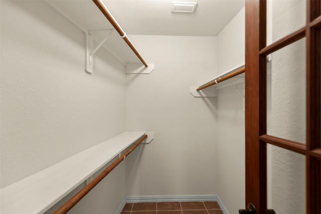 walk in closet with dark tile patterned flooring