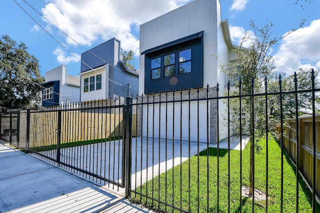 view of gate featuring a lawn and a garage