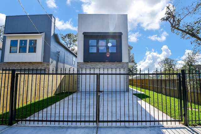 view of gate featuring a garage and a yard