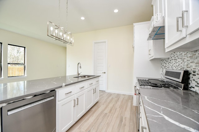 kitchen with white cabinets, stainless steel appliances, light stone countertops, and pendant lighting