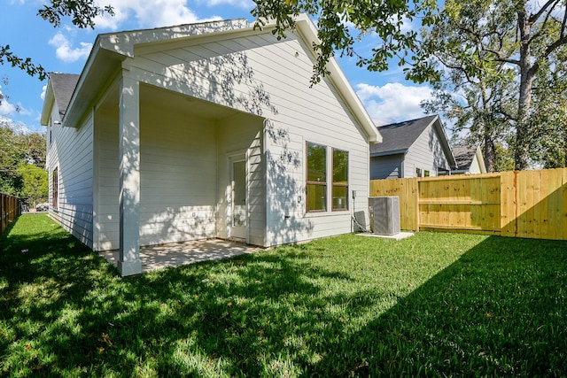 rear view of property featuring a lawn, a patio, and central AC unit