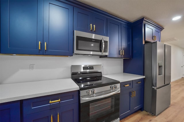 kitchen featuring stainless steel appliances, blue cabinetry, and light hardwood / wood-style floors