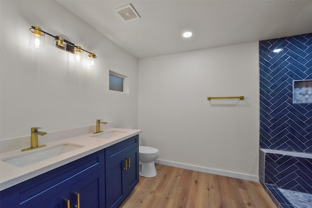 bathroom featuring wood-type flooring, vanity, and toilet