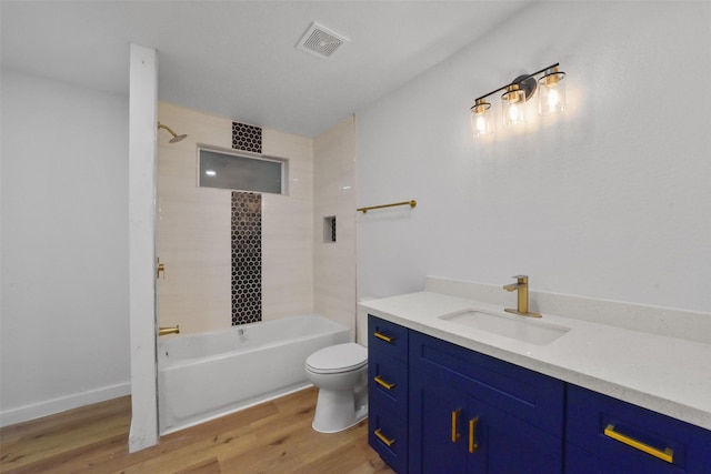 full bathroom with toilet, tiled shower / bath combo, vanity, and hardwood / wood-style floors