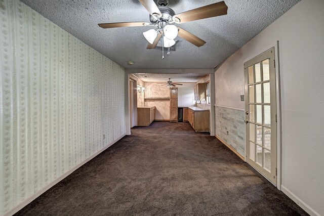 hallway featuring a textured ceiling and dark colored carpet