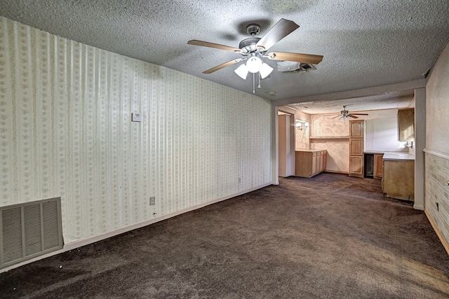 unfurnished living room with a textured ceiling, dark colored carpet, and ceiling fan