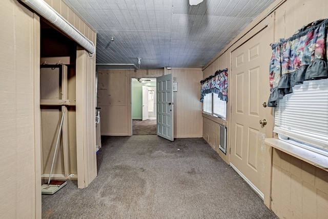 interior space with carpet floors and wooden walls