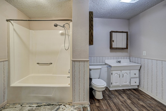 full bathroom featuring a textured ceiling, shower / tub combination, wood-type flooring, and vanity