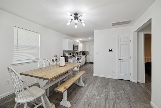 dining space featuring a chandelier and dark hardwood / wood-style flooring