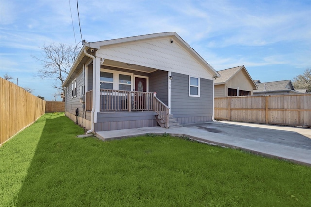 rear view of house with a yard, a porch, and a patio area