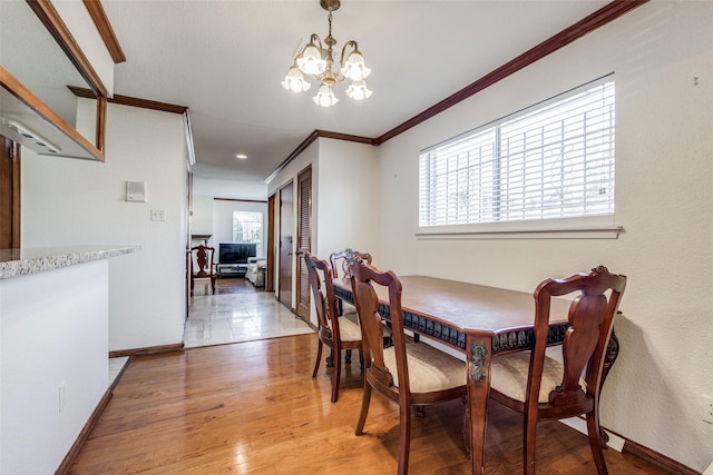 dining space featuring a notable chandelier, ornamental molding, plenty of natural light, and wood-type flooring