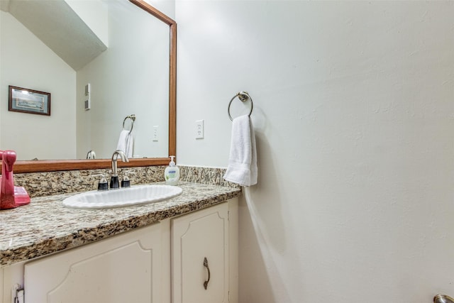 bathroom with lofted ceiling and vanity