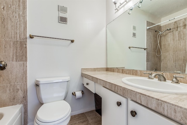 full bathroom with toilet, tiled shower / bath combo, and vanity