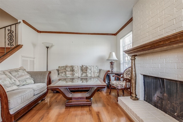 living room featuring a fireplace, ornamental molding, and light hardwood / wood-style flooring