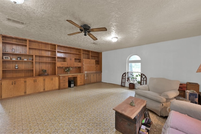 living room featuring a textured ceiling and ceiling fan