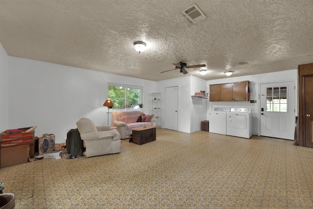 living room with washer and dryer, a textured ceiling, and plenty of natural light