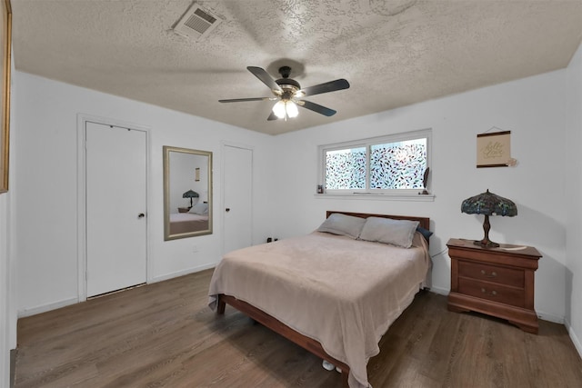 bedroom featuring a textured ceiling, ceiling fan, and dark hardwood / wood-style floors