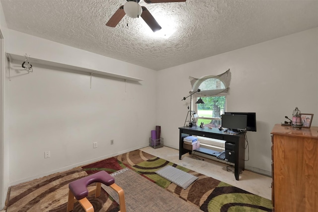 misc room with a textured ceiling, light colored carpet, and ceiling fan