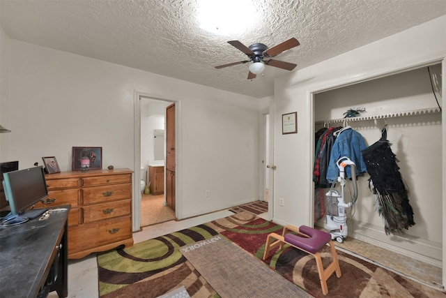 carpeted bedroom with ceiling fan, a closet, ensuite bath, and a textured ceiling