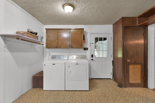 washroom with a textured ceiling, cabinets, and independent washer and dryer