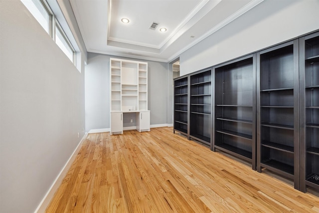 spacious closet with wood-type flooring and a tray ceiling