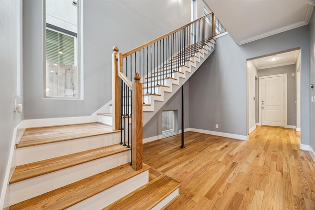 staircase featuring hardwood / wood-style floors and ornamental molding