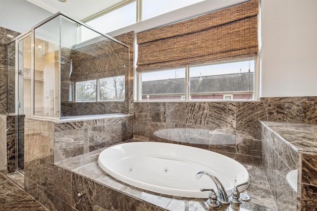 bathroom with a wealth of natural light and separate shower and tub