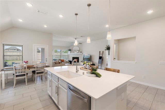 kitchen featuring ceiling fan, stainless steel dishwasher, a center island with sink, and decorative light fixtures