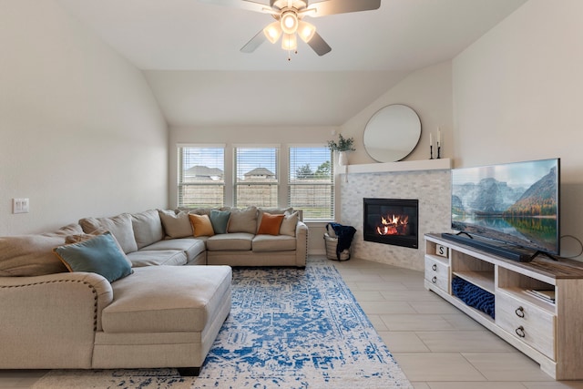 living room with ceiling fan, lofted ceiling, and a fireplace