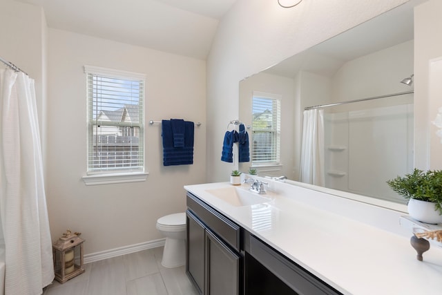 bathroom featuring vaulted ceiling, toilet, a wealth of natural light, and vanity