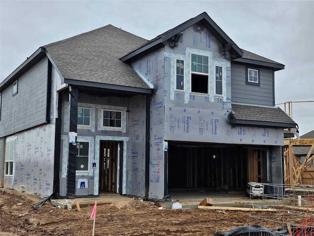 property under construction with a shingled roof and a garage